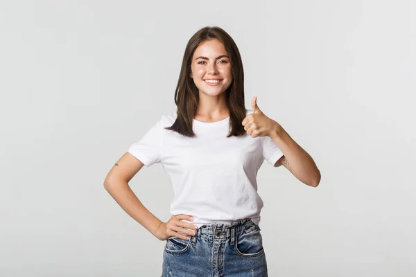 Feliz satisfeito jovem mulher sorrindo, mostrando polegar-se em aprovação, como algo — Fotografia de Stock