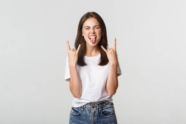Neşeli, güzel bir kız rock jesti yapıyor ve konserden zevk alıyor.
