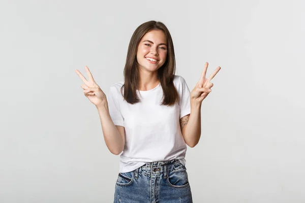 Joven atractiva alegre sonriendo, mostrando gestos de paz —  Fotos de Stock