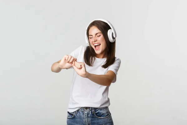 Fröhlich schöne junge Frau tanzt, genießt Musik in drahtlosen Kopfhörern — Stockfoto