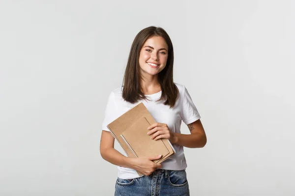 Feliz estudiante sonriente sosteniendo cuadernos, solicitar cursos o universidad —  Fotos de Stock
