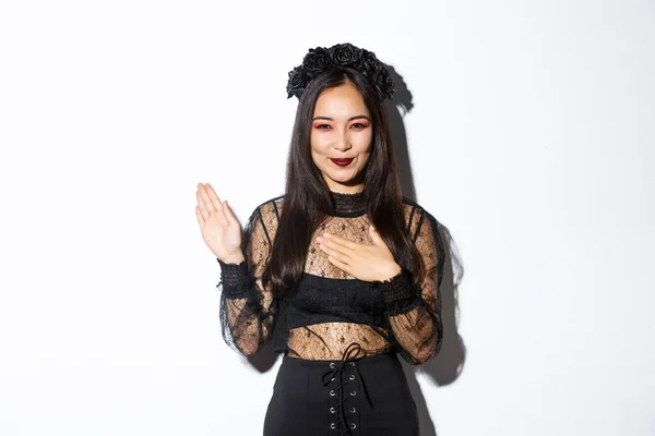 Imagem de mulher bonita sorrindo fazendo promessa, dar juramento em seu coração, levantando um braço e olhando para a câmera sincera, de pé sobre fundo branco — Fotografia de Stock