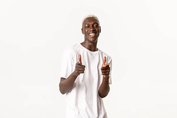 Retrato de chico rubio afro-americano atractivo alegre, sonriendo complacido y señalando con los dedos a la cámara, alabándote, fondo blanco — Foto de Stock