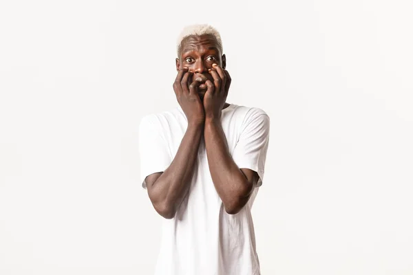 Retrato de chico rubio afroamericano emocionado y tentado, temblando de emoción, fondo blanco de pie — Foto de Stock