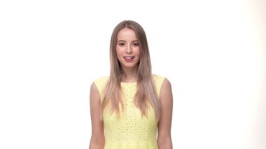 Mutlu genç bir kadın, beyaz arka planda izole edilmiş parmaklarıyla tamam işareti gösteriyor..