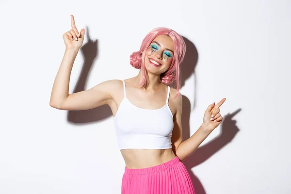 Portret van gelukkig mooi meisje dat plezier heeft, danst en lacht, feestdagen viert op feest, roze pruik draagt met heldere make-up — Stockfoto