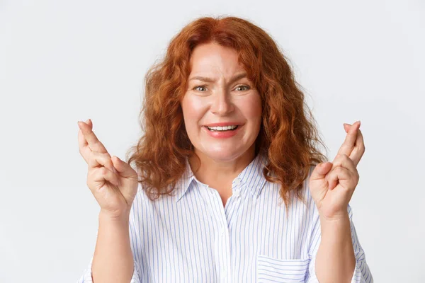 People, emotions and lifestyle concept. Close-up of hopeful smiling middle-aged woman feeling nervous and tempting while making wish, cross fingers good luck, waiting for announcement — Stock Photo, Image