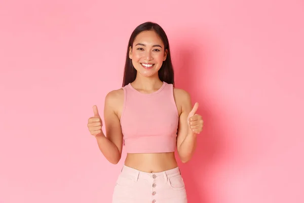 Estilo de vida, beleza e conceito de mulher. Retrato de satisfeito e confiante boa aparência asiática menina em roupas de verão mostrando polegares para cima e sorrindo, aprovar a escolha, elogio ou louvor bom trabalho — Fotografia de Stock