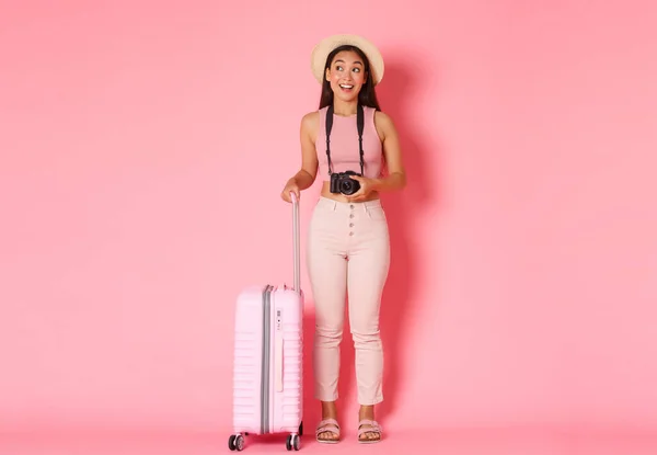 Turismo, vacanze estive, vacanze all'estero concetto. Piena lunghezza di sognante e divertito ragazza asiatica viaggiatore, turista guardando con stupore lateralmente, tenendo la fotocamera, vuole fare foto dal viaggio — Foto Stock