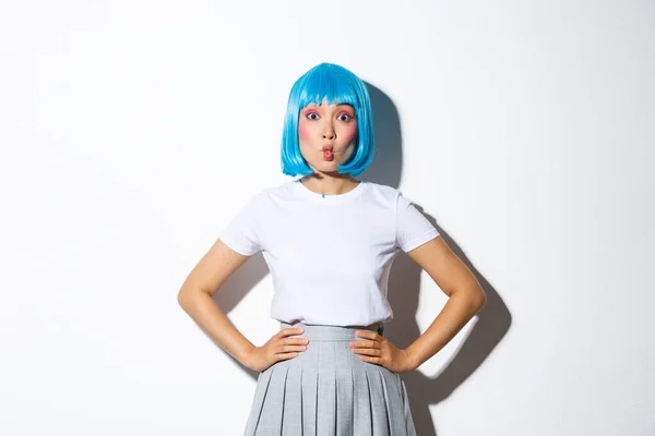 Portret pięknej koreańskiej dziewczyny dąsającej się coquettish, patrząc na aparat głupie, stojąc w niebieskiej peruce i strój party na Halloween — Zdjęcie stockowe