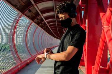 Genç koşucu egzersizin zamanını kontrol ediyor 