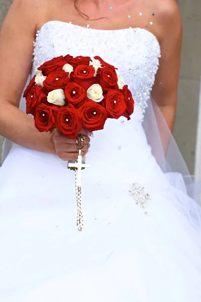 bride with red flowers and cross