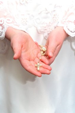 Kutsal komünyon kızı elinde haç tutuyor.
