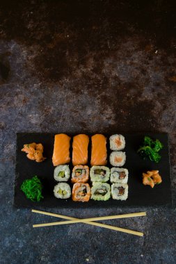 Suşi Sashimi ve suşi ruloları taş levhada servis edilir.