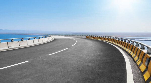 Драматическая кривая возвышенности шоссе против красивого голубого неба.