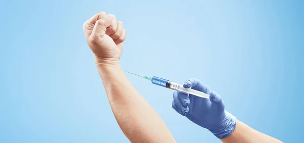 Läkarhand Med Spruta För Injektion Annan Hand Ljusblå Bakgrund Medicinskt — Stockfoto