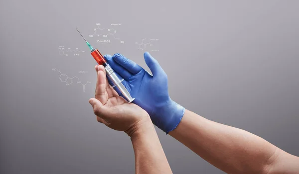 Doctor hands with medical needle syringe drug. Chemistry molecule structure code against grey background. Medical concept for health care, research, and science.