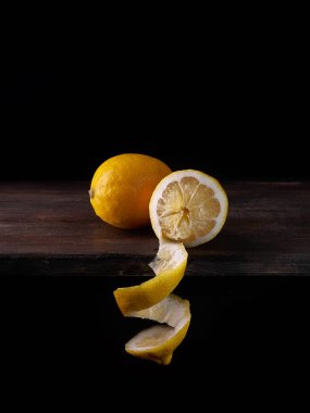 Koyu arkaplanda tahta bir masada iki limon.