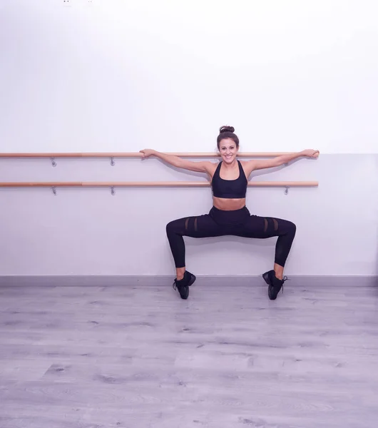 Smiling woman doing stretching on bar — Stock Photo, Image