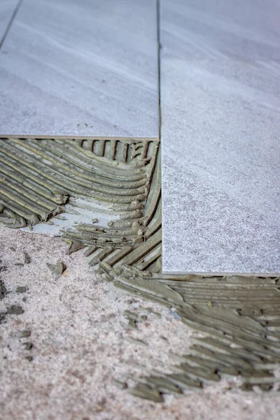 Установка плитки с клеем на бетонный пол — стоковое фото