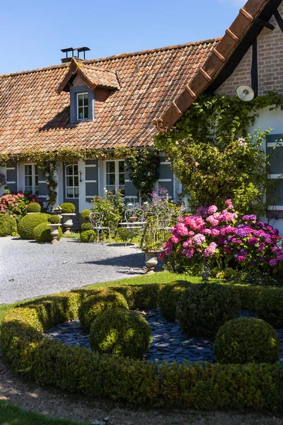 Yazın mavi gökyüzü olan büyük çiçek bahçesinde güzel bir ev.