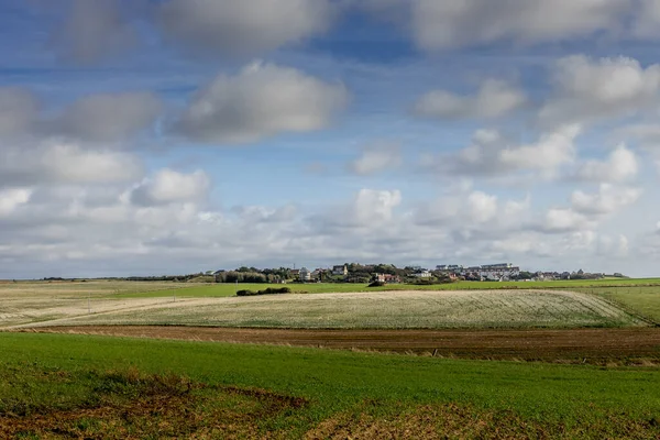 Kırsal kesimde bir köy. Bulutlu tarlalar ve gökyüzü