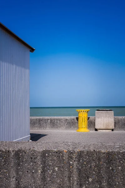 Cabana de madeira com lixo amarelo na praia na Normandia. — Fotografia de Stock