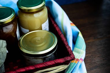 Gourmet ürünleri, kavanozlar ve yerel ürünlerin korunduğu hediye sepeti.