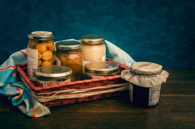 Gourmet ürünleri, kavanozlar ve yerel ürünlerin korunduğu hediye sepeti.