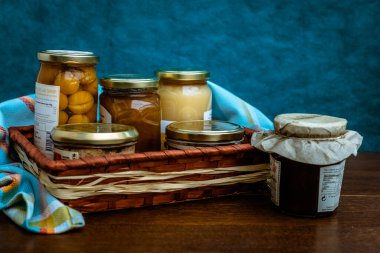 Gourmet ürünleri, kavanozlar ve yerel ürünlerin korunduğu hediye sepeti.