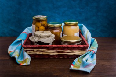 Gourmet ürünleri, kavanozlar ve yerel ürünlerin korunduğu hediye sepeti.