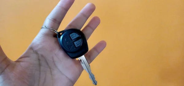 Uzaktan kumandalı, turuncu arka plan duvarlı, merkezi kilit sistemi olan bir kişi