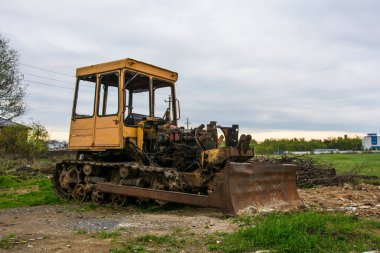 Paslı terk edilmiş traktör, yeşil ormanda terk edilmiş.
