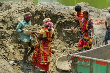 Howrah, Batı Bengal, Hindistan - 7 Mayıs 2017: Hintli erkek ve kadın işçiler hızla yükselen inşaat alanında toprak kazıp çıkarıyorlar. Hindistan 'ın günlük kazancı çok fazla..