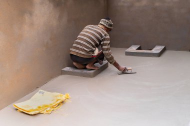 Howrah, Batı Bengal, Hindistan - 6 Ocak 2020: Hindistan işçi sınıfı, düz mala ve beton kullanarak alçılı zemini elle düzleştiriyor. Resim yükle.