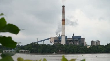 Howrah, Batı Bengal, Hindistan - 19 Ekim 2018: Ganj nehrinin diğer yakasında beyaz duman yayan bir fabrikanın bacası.