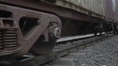 Howrah, Batı Bengal, Hindistan - 19 Ekim 2018: Hindistan yük treninin demiryolunda yavaşça geçişi düşük açılı görüntüsü. Vagonun alt tarafı ve tren yolu görünüyor..