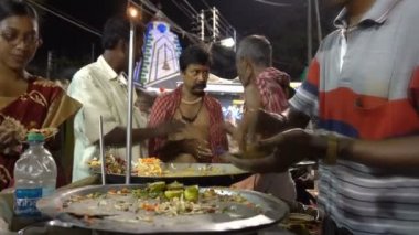 Howrah, Batı Bengal, Hindistan - 14 Nisan 2019: Yol kenarında Hint Bengali yemekleri yapan sokak satıcısı, Gajan ya da Charak festivali olarak bilinen Bengali yılbaşını gece kutluyor..