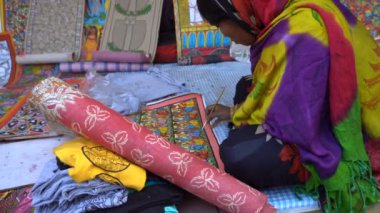 Kolkata, Batı Bengal, Hindistan - 31 Aralık 2018: Hintli kadın sanatçı el sanatları üzerine renk çiziyor. Hint el sanatları renkli ve detaylı sanatlarıyla ünlüdür..
