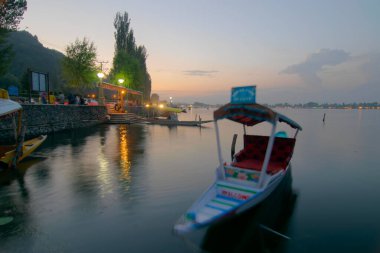 Shree Nagar, Jammu ve Kashmir, Hindistan-31 Ağustos 2014: Günbatımından sonra Dal Gölü manzarası, arka planda akşam gökyüzü olan yüzen yüzen yüzen yüzen yüzen yüzen tekneler. Dünyanın dört bir yanından önemli turistik cazibe merkezi..