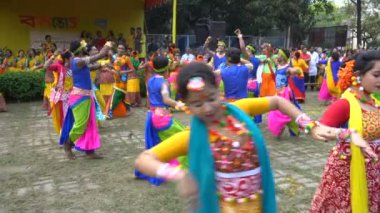 Kolkata, Batı Bengal, Hindistan - 9 Mart 2020: Hint sarisi giymiş bir grup kadın ve Lord Krishna 'yı oynayan bir erkek dansçı, Holi festivalinde seyirci eşliğinde dans ediyorlar. Kolkata 'da bahar.