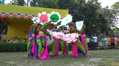 Kolkata, Batı Bengal, Hindistan - 9 Mart 2020: Hint sarisi giymiş bir grup kadın ve Lord Krishna 'yı oynayan bir erkek dansçı, Holi festivalinde seyirci eşliğinde dans ediyorlar. Kolkata 'da bahar.