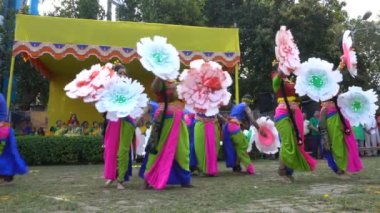 Kolkata, Batı Bengal, Hindistan - 9 Mart 2020: Hint sarisi giymiş bir grup kadın ve Lord Krishna 'yı oynayan bir erkek dansçı, Holi festivalinde seyirci eşliğinde dans ediyorlar. Kolkata 'da bahar.