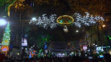 Kolkata, Batı Bengal, Hindistan - 25 Aralık 2018: Noel kutlaması için dekoratif ışıklarla aydınlatılmış Park Caddesi 'nde yürüyen neşeli vatandaşlar. Gece boyu eğlence.