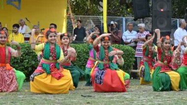Kolkata, Batı Bengal, Hindistan - 10 Mart 2020: Renkli Hint elbiseleri giymiş neşeli Bengalli kız dansçılar, Dol utsab veya Holi festivalinde dans ediyorlar. Hindistan 'da bahar kutlaması. 4K stok görüntüsü.