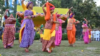 Kolkata, Batı Bengal, Hindistan - 10 Mart 2020: Bengalli kızlar renkli Hint elbiseleri giyip Dol utsab veya Holi festivalinde dans ediyorlar. Hindistan 'a baharın gelişini kutluyoruz. 4K stok görüntüsü.