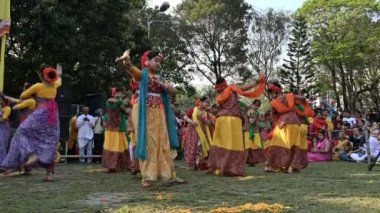 Kolkata, Batı Bengal, Hindistan - 10 Mart 2020: Dol utsab veya Holi festivalinde dans eden renkli Hint elbiseli genç Bengalli bayan dansçılar. Hindistan 'da bahar kutlaması. 4K stok görüntüsü.