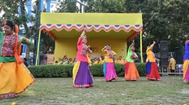Kolkata, Batı Bengal, Hindistan - 10 Mart 2020: Renkli geleneksel Hint elbiseli genç Bengalli kızlar, Dol utsab veya Holi festivalinde dans ediyorlar. Hindistan 'a baharın gelişini kutluyoruz. 4K.