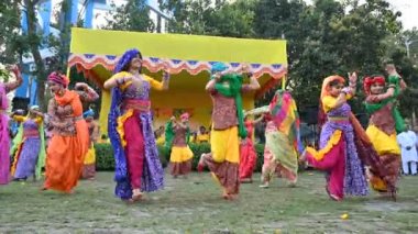 Kolkata, Batı Bengal, Hindistan - 10 Mart 2020: Dol utsab veya Holi festivalinde renkli Hint elbiseleri giymiş Bengalli kızların dans gösterisi. Hindistan 'da bahar kutlaması. 4K stok görüntüsü.