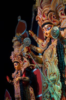 Durga ve Laxmi heykelleri Durga Puja pandalında, Durga Puja festivalinde gece. Howrah, West Bengal, Hindistan 'da renkli ışığın altında çekildi..